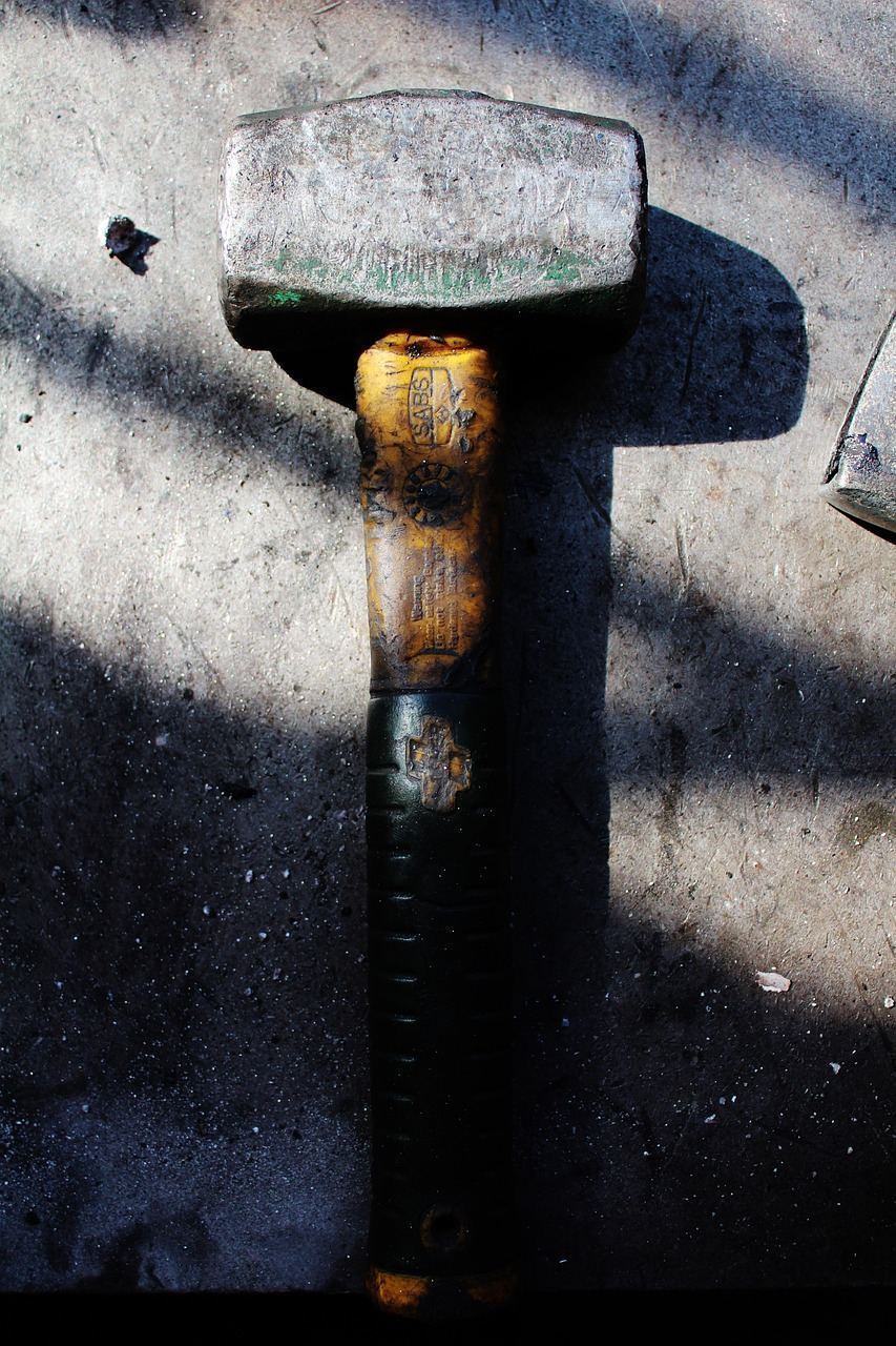 Close-up of a technician working on an air conditioning unit with tools on a sunny day.