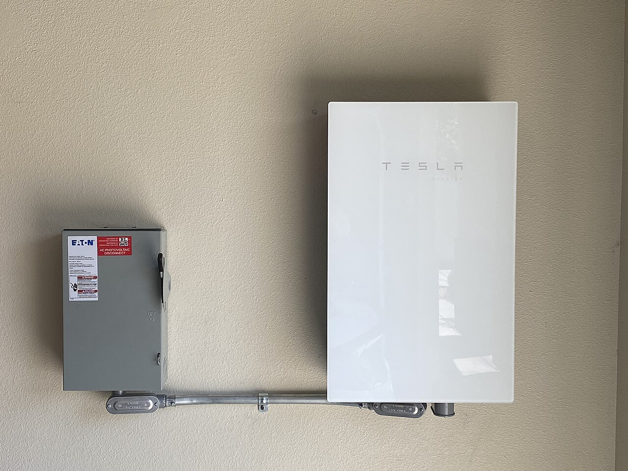 Outdoor AC disconnect box mounted beside the unit — the pull-out switch you test before touching anything inside (CC BY-SA 4.0, Wikimedia Commons)